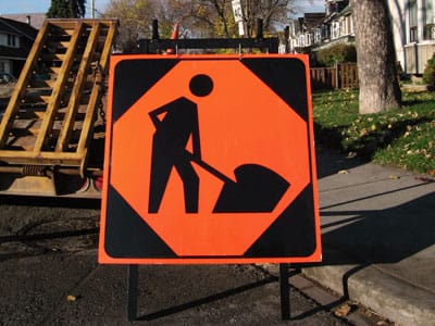 sign with worker digging