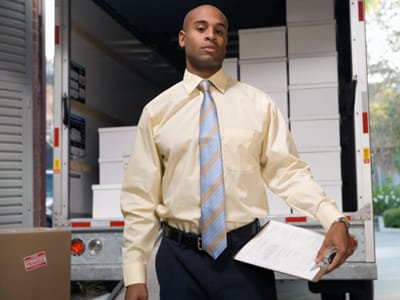 image of man in business attire, in front of moving truck