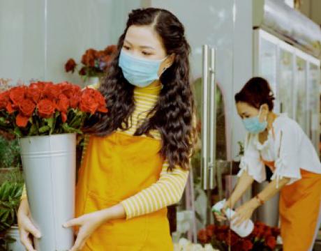 florist preparing roses while wearing a face mask